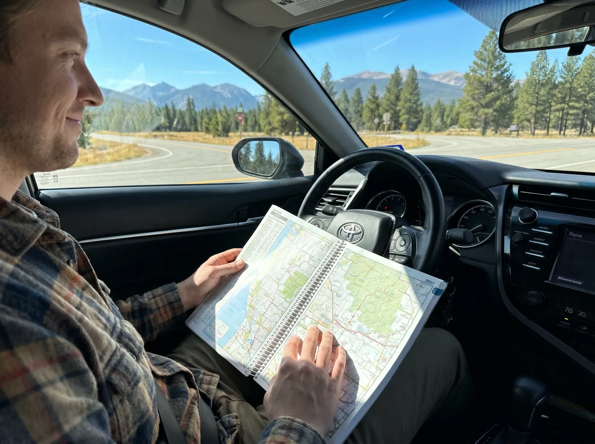 MapBound atlas open across a lap with a route being traced during trip planning