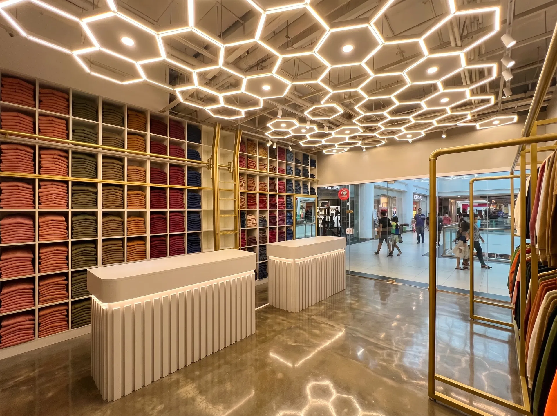 Interior da loja Tee Fashion &mdash; prateleiras com cores OI 2026