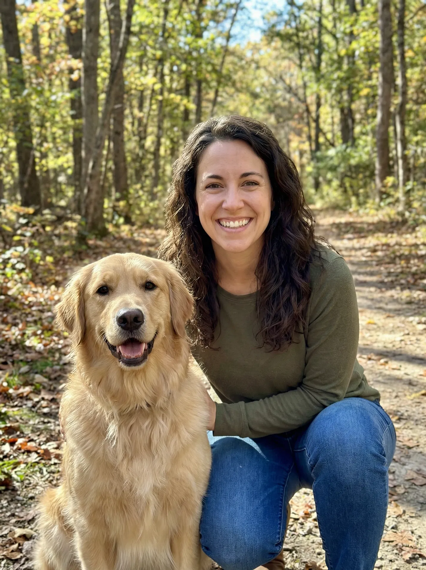 Olivia Brown, author of Regain Control, walking her golden retriever in an autumn woodland