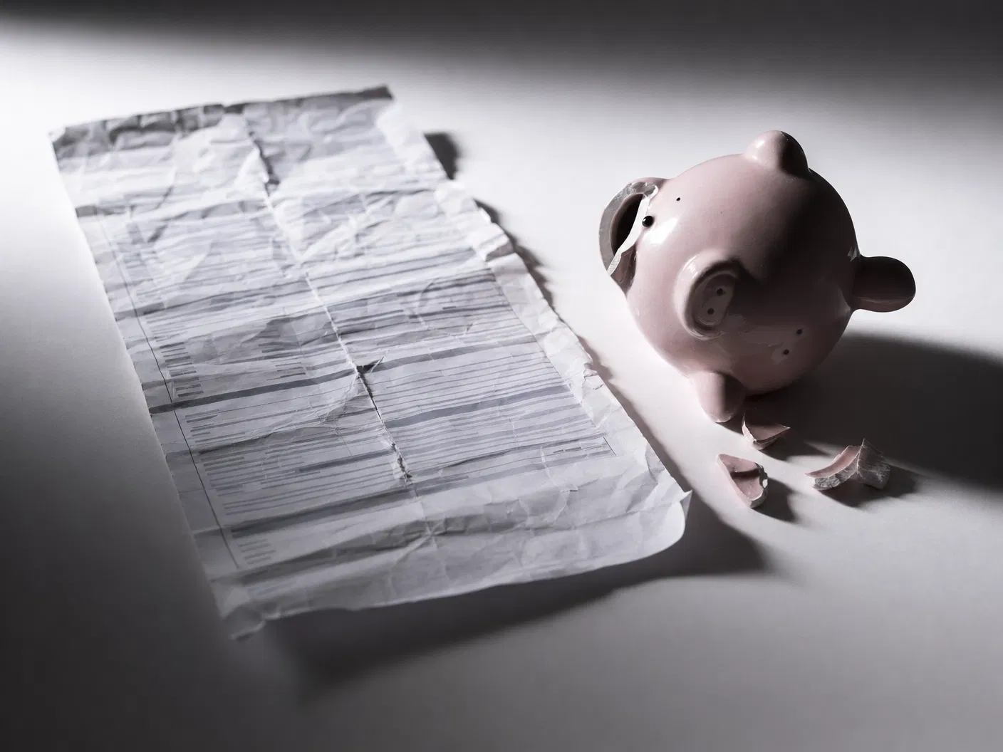 Broken healthcare system — crumpled medical bill and broken piggy bank