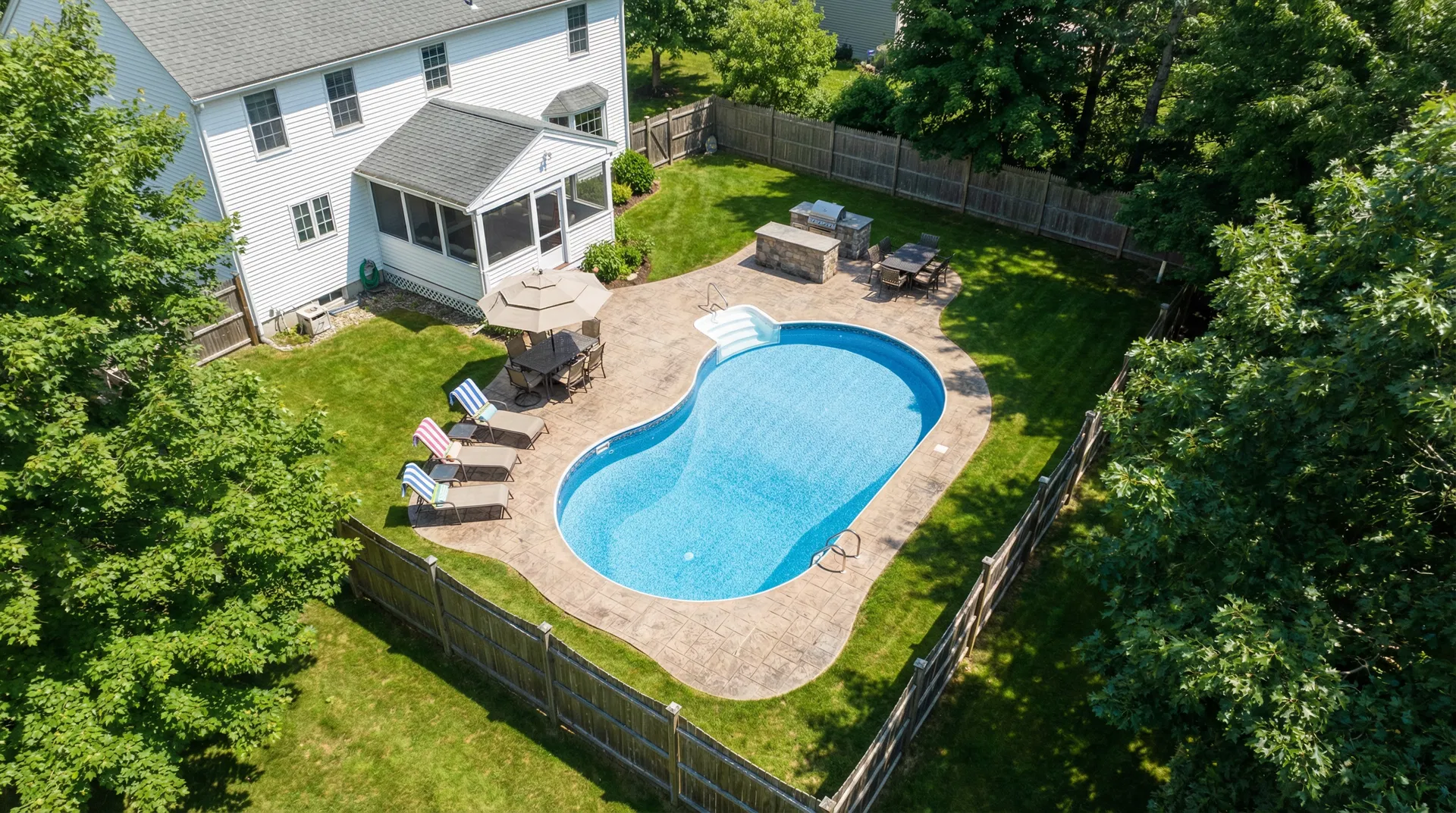 Beautiful freeform vinyl liner pool with waterfall in New England backyard