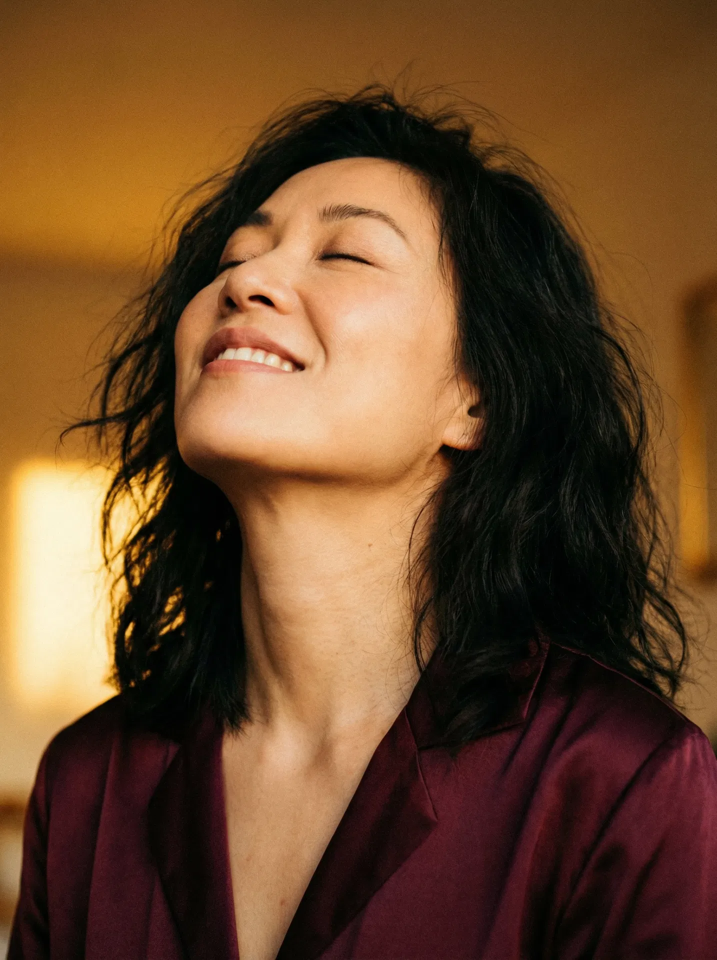 Asian woman in transcendent state, eyes closed, head tilted back