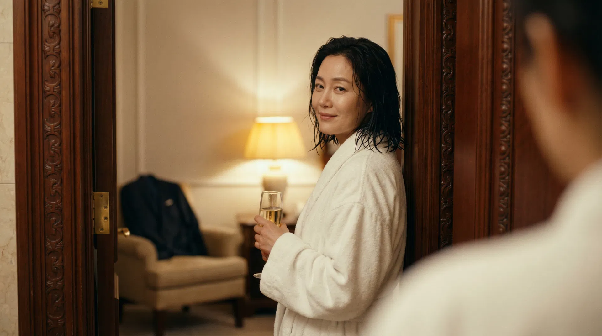 Chinese woman in red silk robe on hotel bed, man's shirt on bedpost