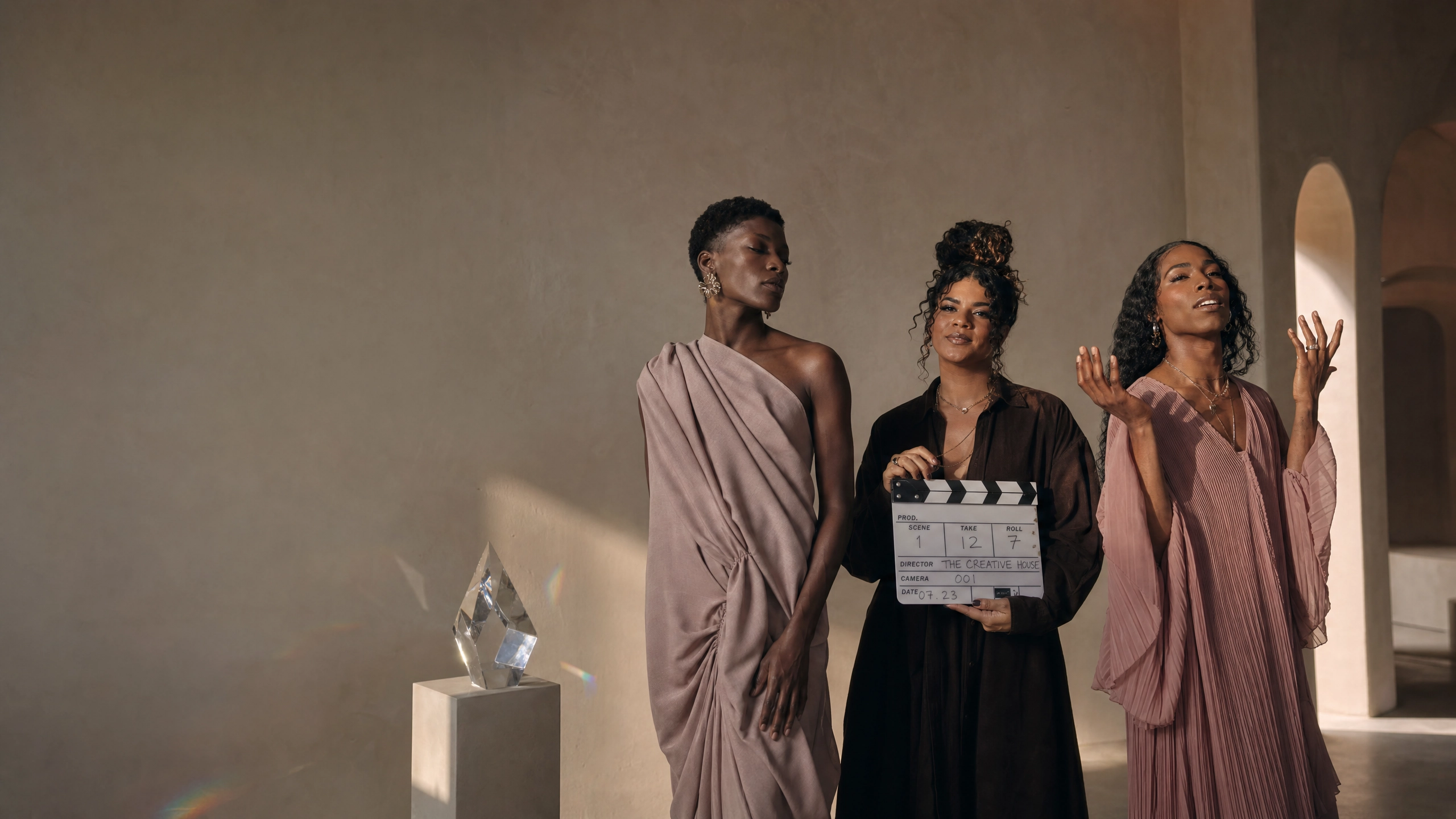 Iridescent Colors creative house — three Black and Brown trans and queer creatives in a sunlit gallery space