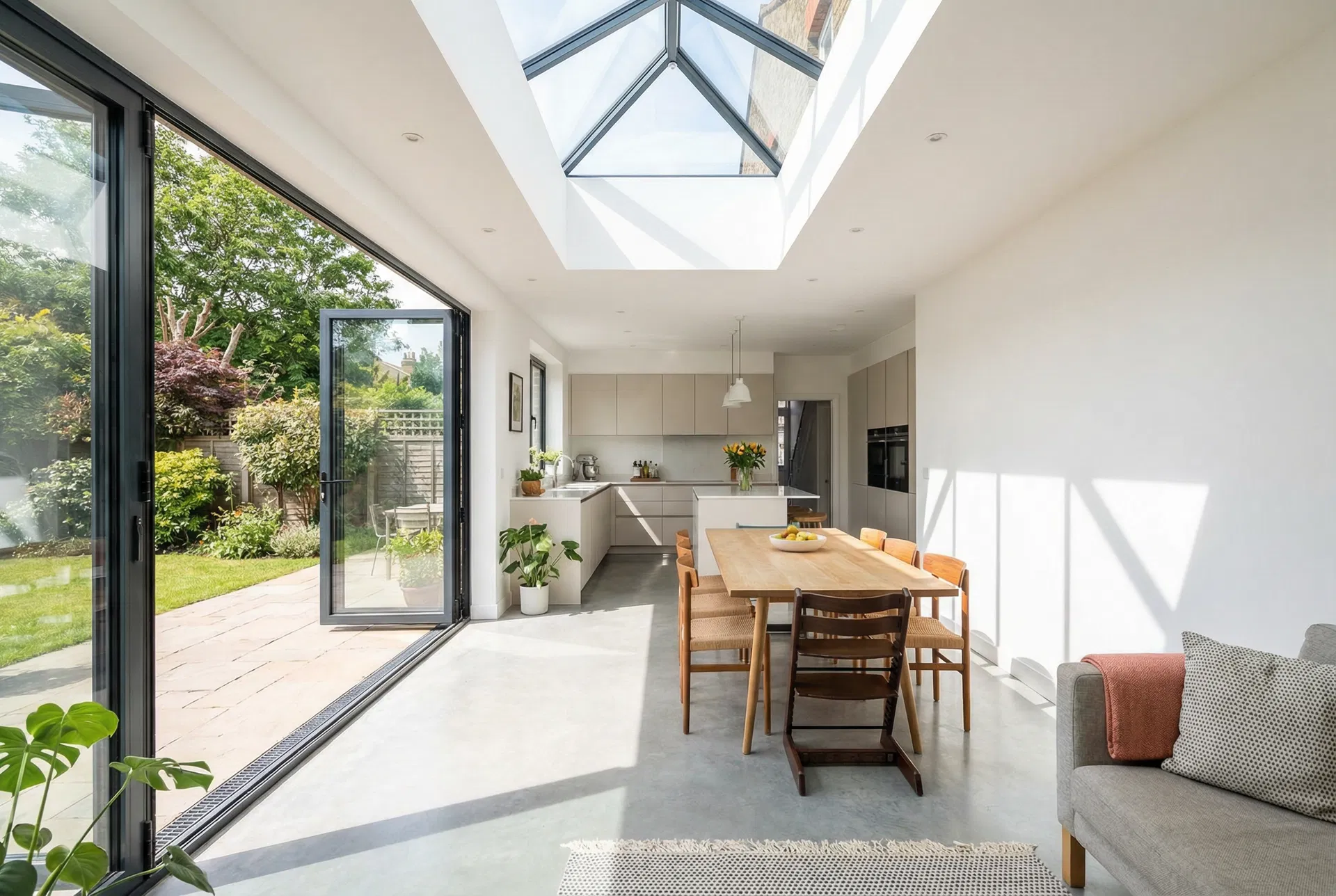 Rear house extension with bi-fold doors open to garden at dusk by Ross-Read Building Services Poole