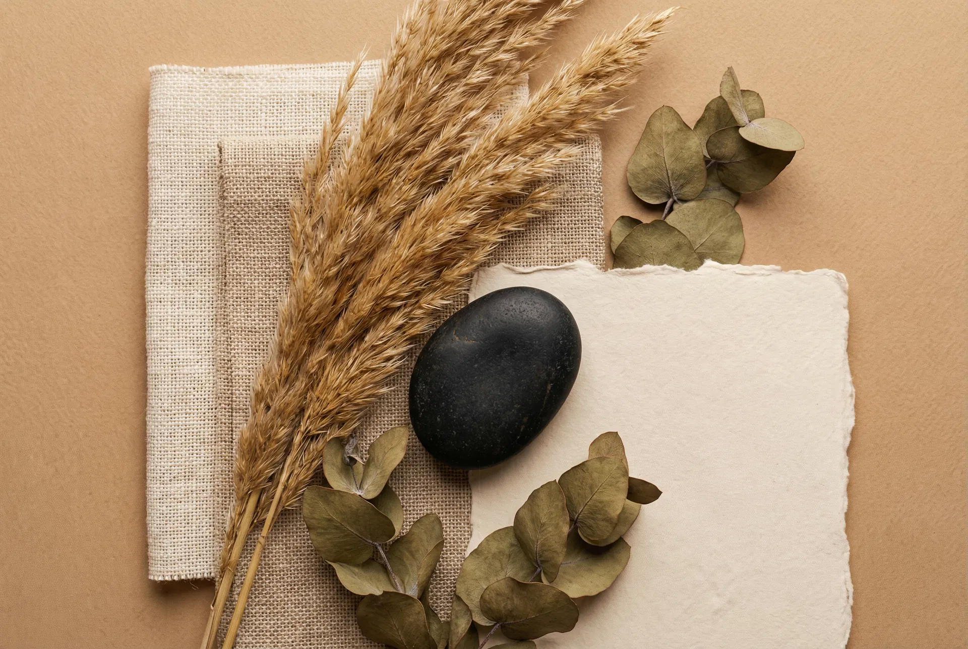 Natural textures — dried botanicals, linen, and stone