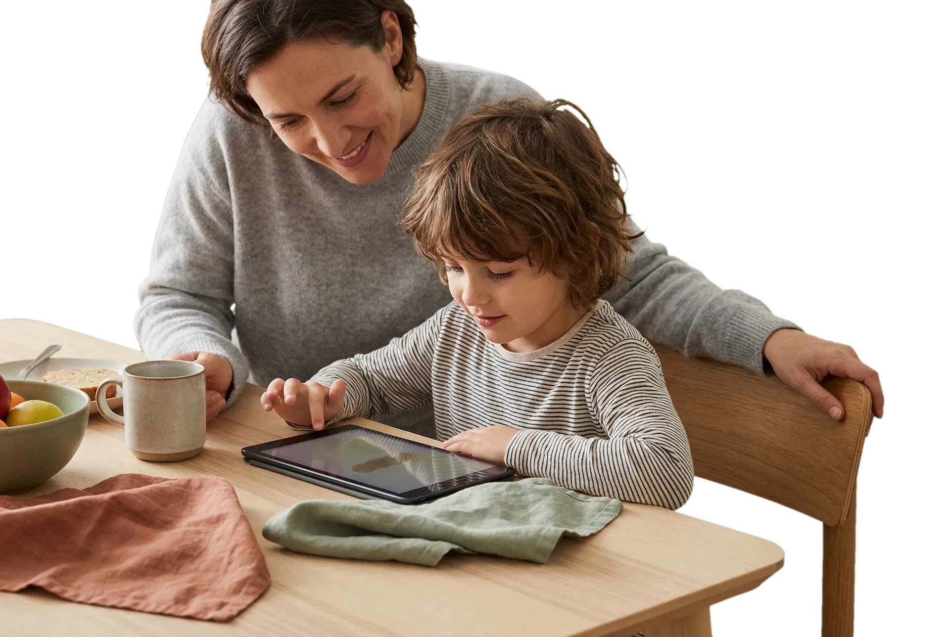 Jeune enfant utilisant une tablette sous la supervision calme d’un parent