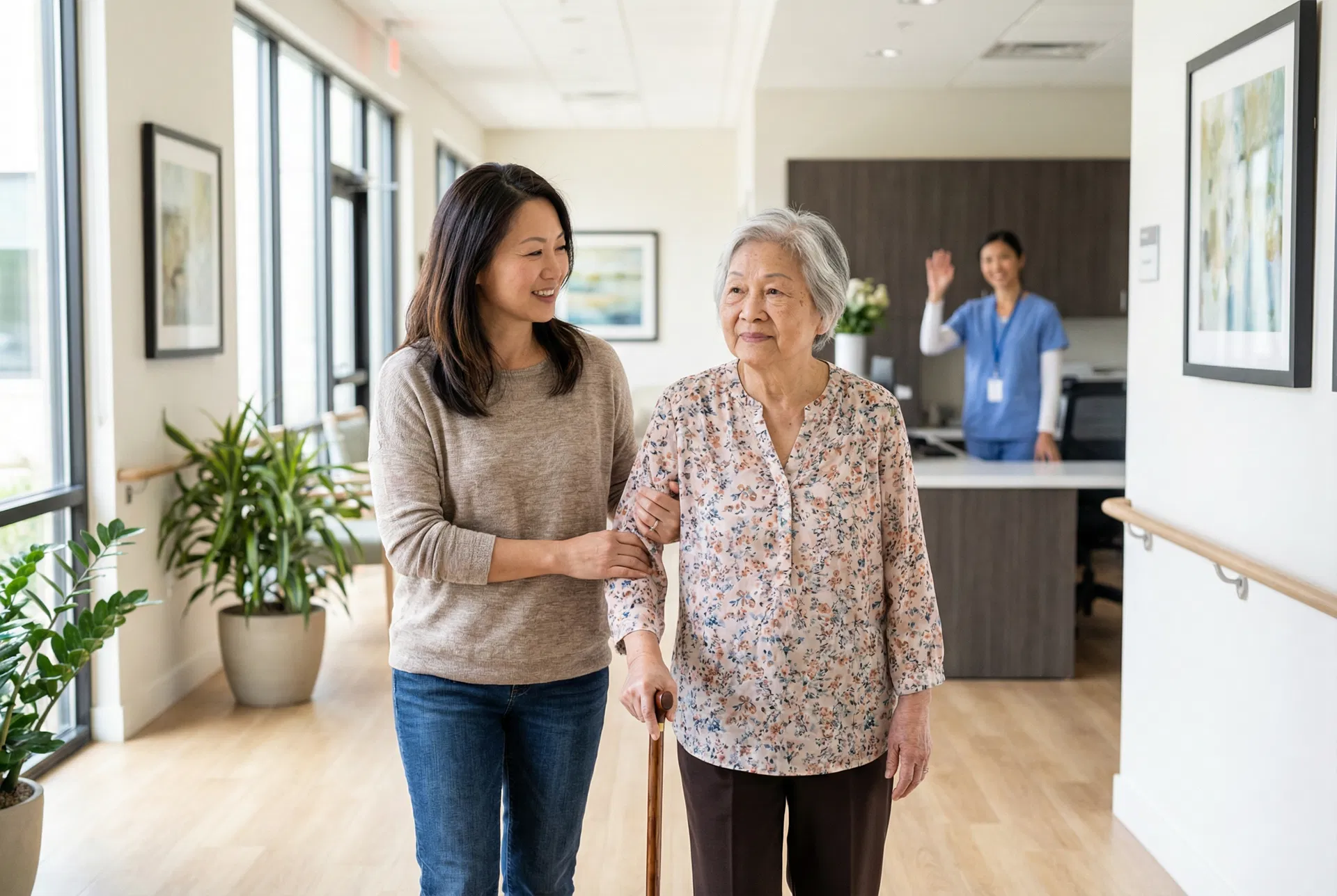 Asian daughter walking with elderly mother through assisted living facility