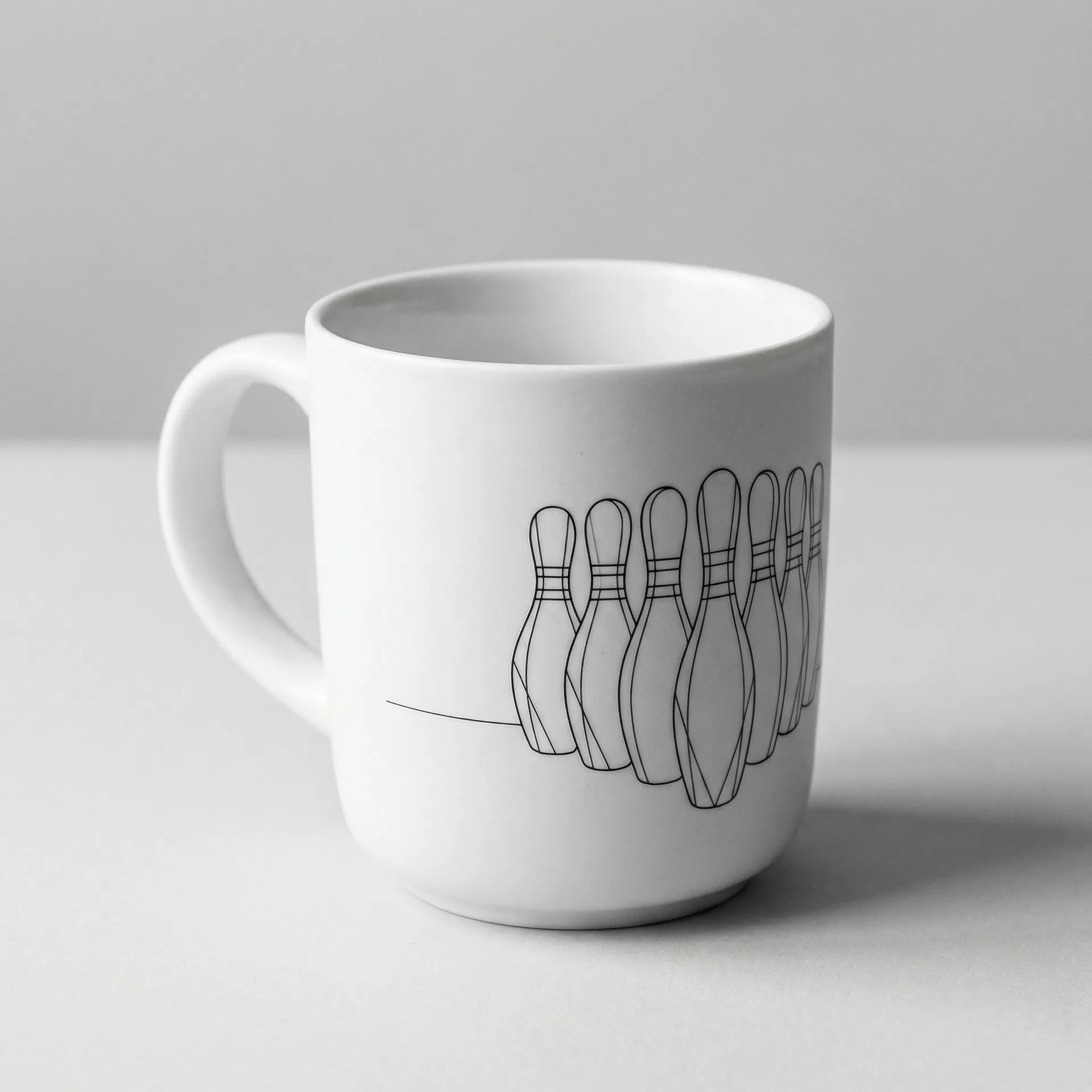 White ceramic mug with minimalist bowling pin line art