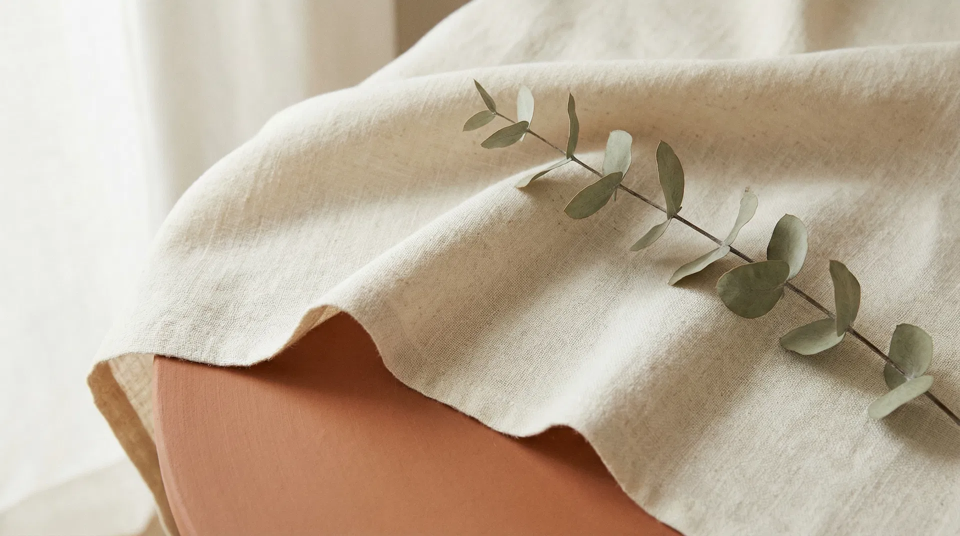 Natural linen fabric draped over terracotta clay