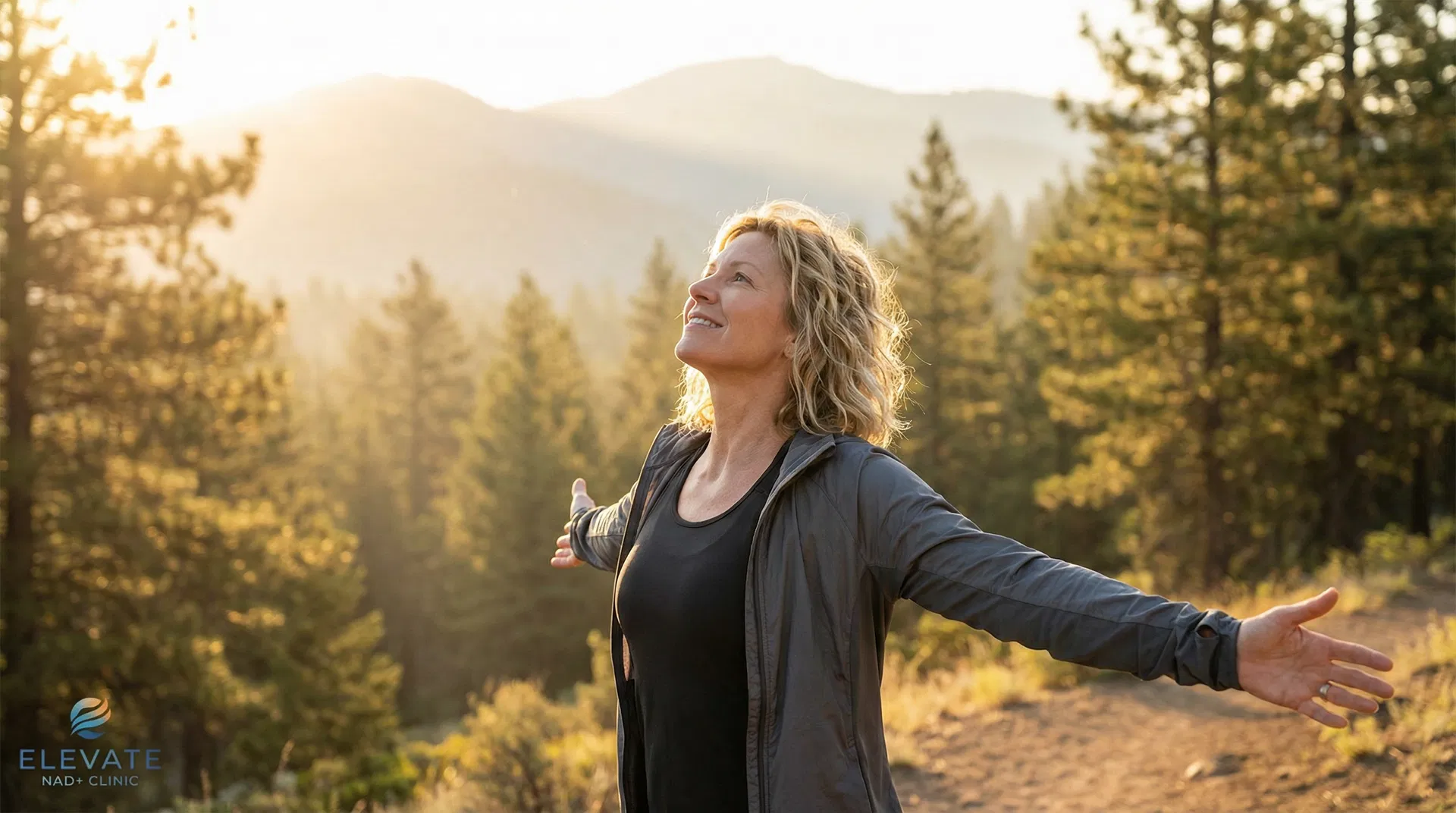 Woman with arms open in a sunlit forest — NAD+ therapy
