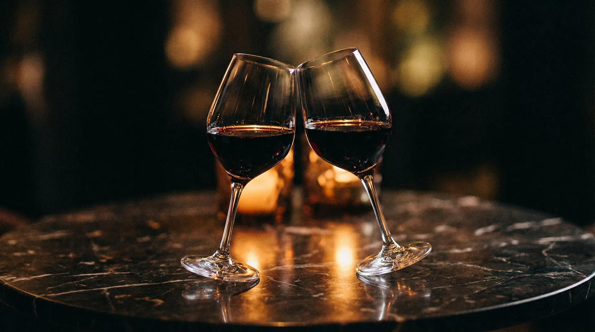 Two wine glasses clinking in a candlelit restaurant
