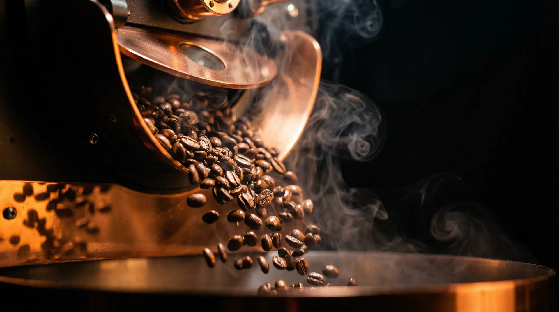 Freshly roasted coffee beans tumbling from a copper drum roaster