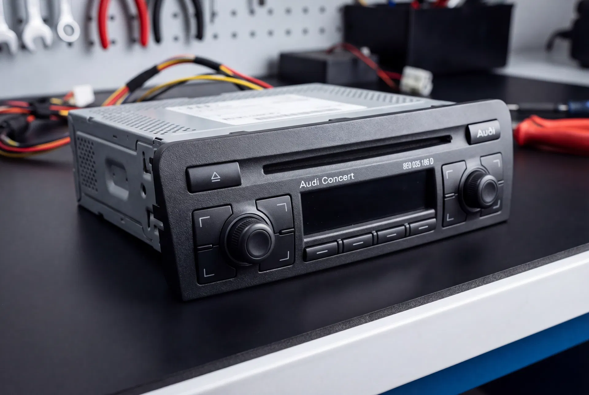 Audi Concert radio unit on a workshop bench showing the front panel and CD slot