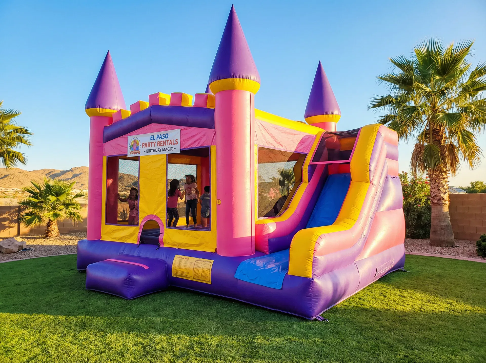 Large colorful jumping castle bounce house rental set up at a backyard birthday party in El Paso TX by Sweet & Sassy Creations