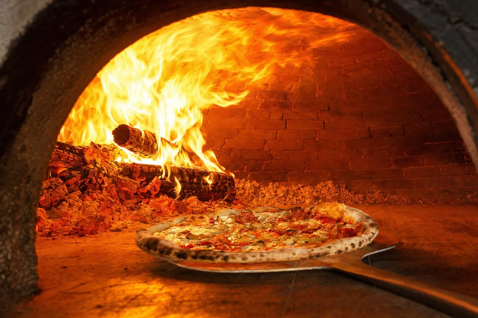 Interior of roaring wood-fired stone pizza oven