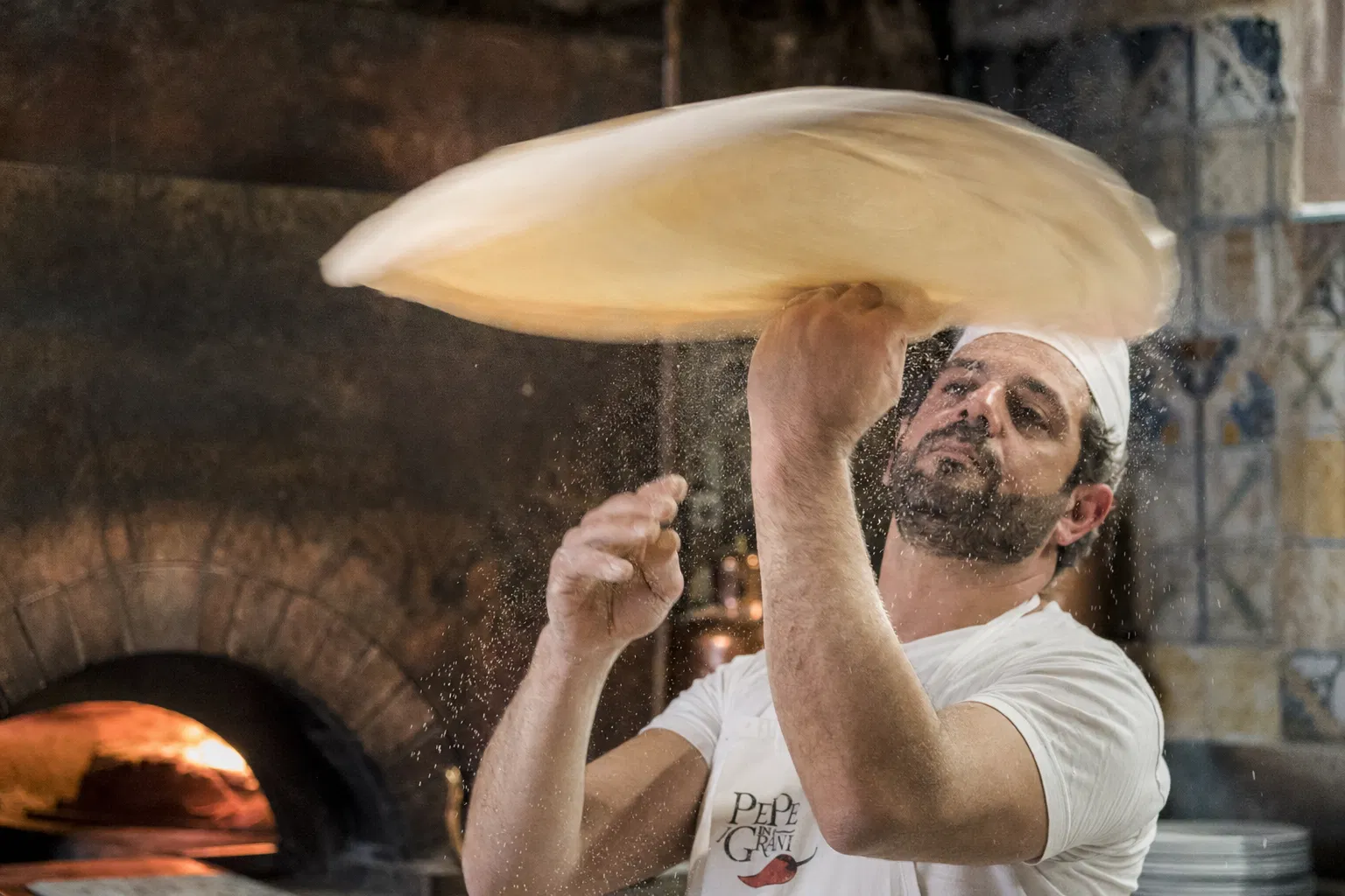 Chef spinning pizza dough in the air