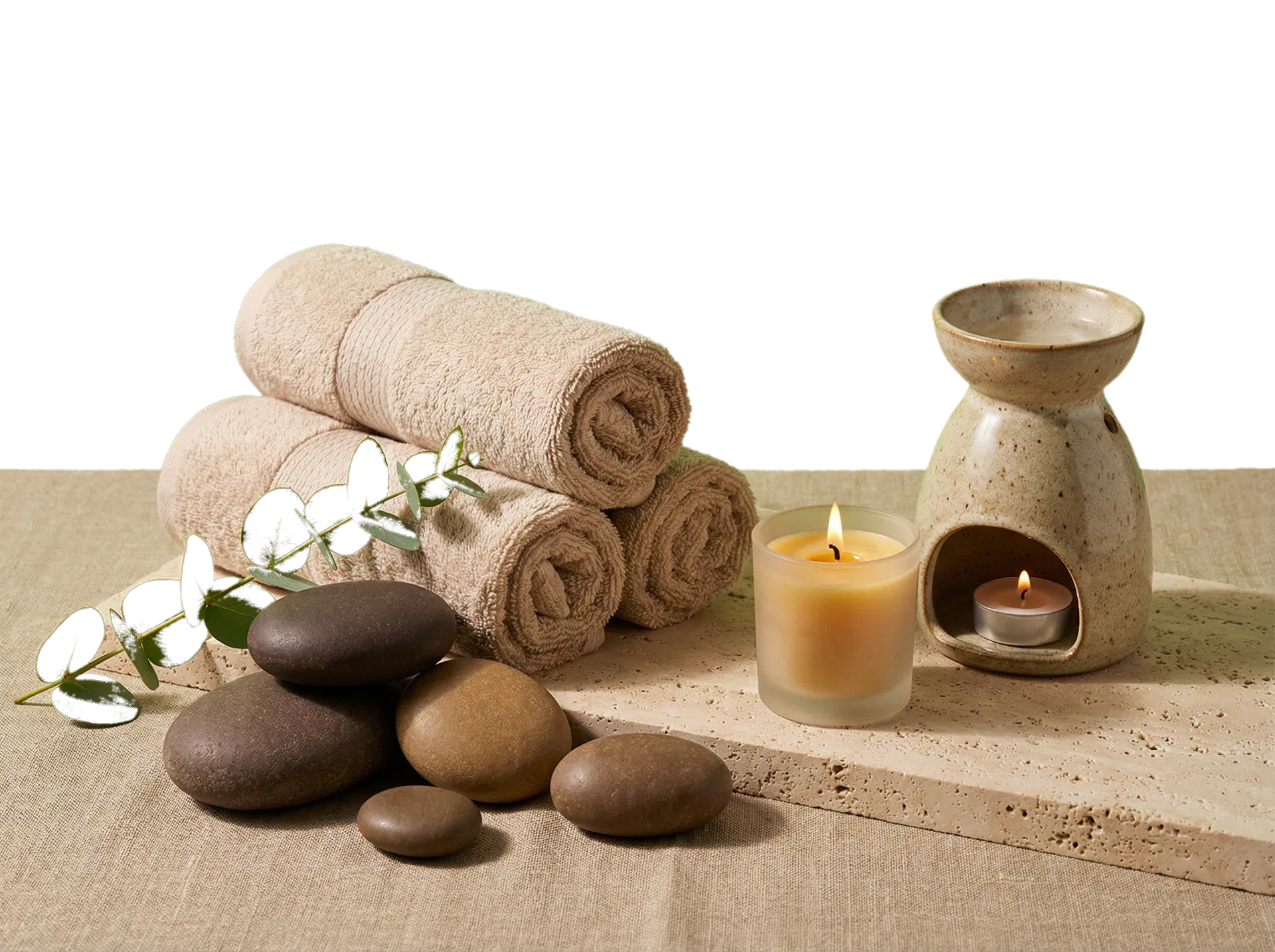 Spa ambience with towels, candle, and massage stones