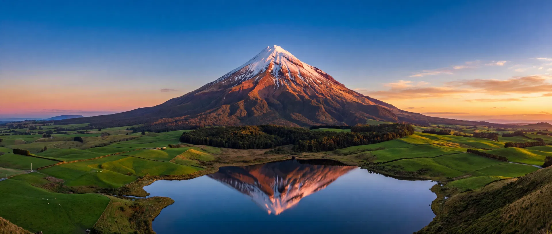Mount Taranaki panoramic landscape with lake reflection at golden hour