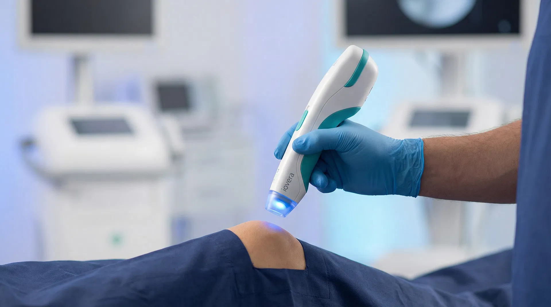 iovera behandling – lege holder iovera-enhet mot pasientens kne