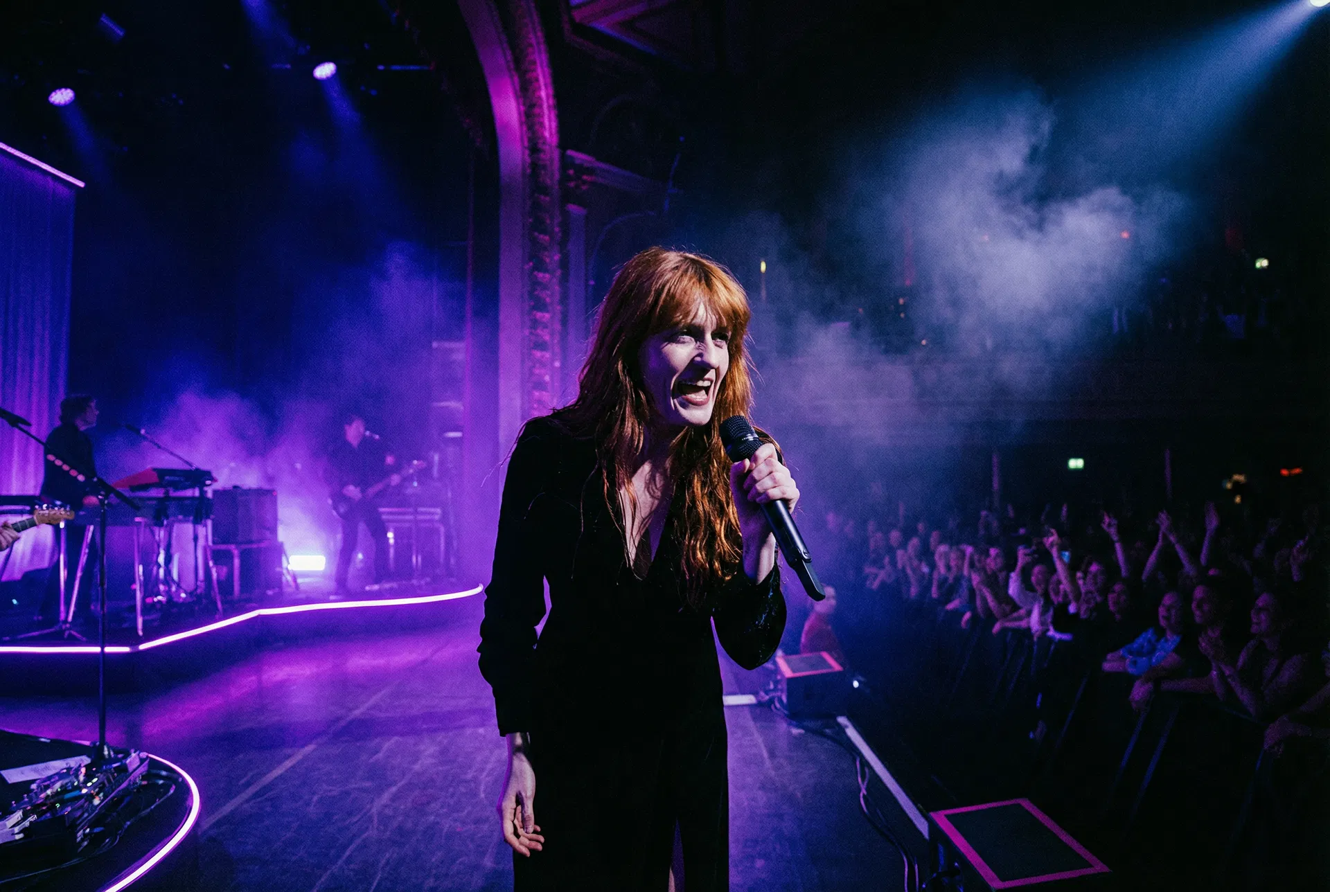 Musician performing on stage with purple stage lighting