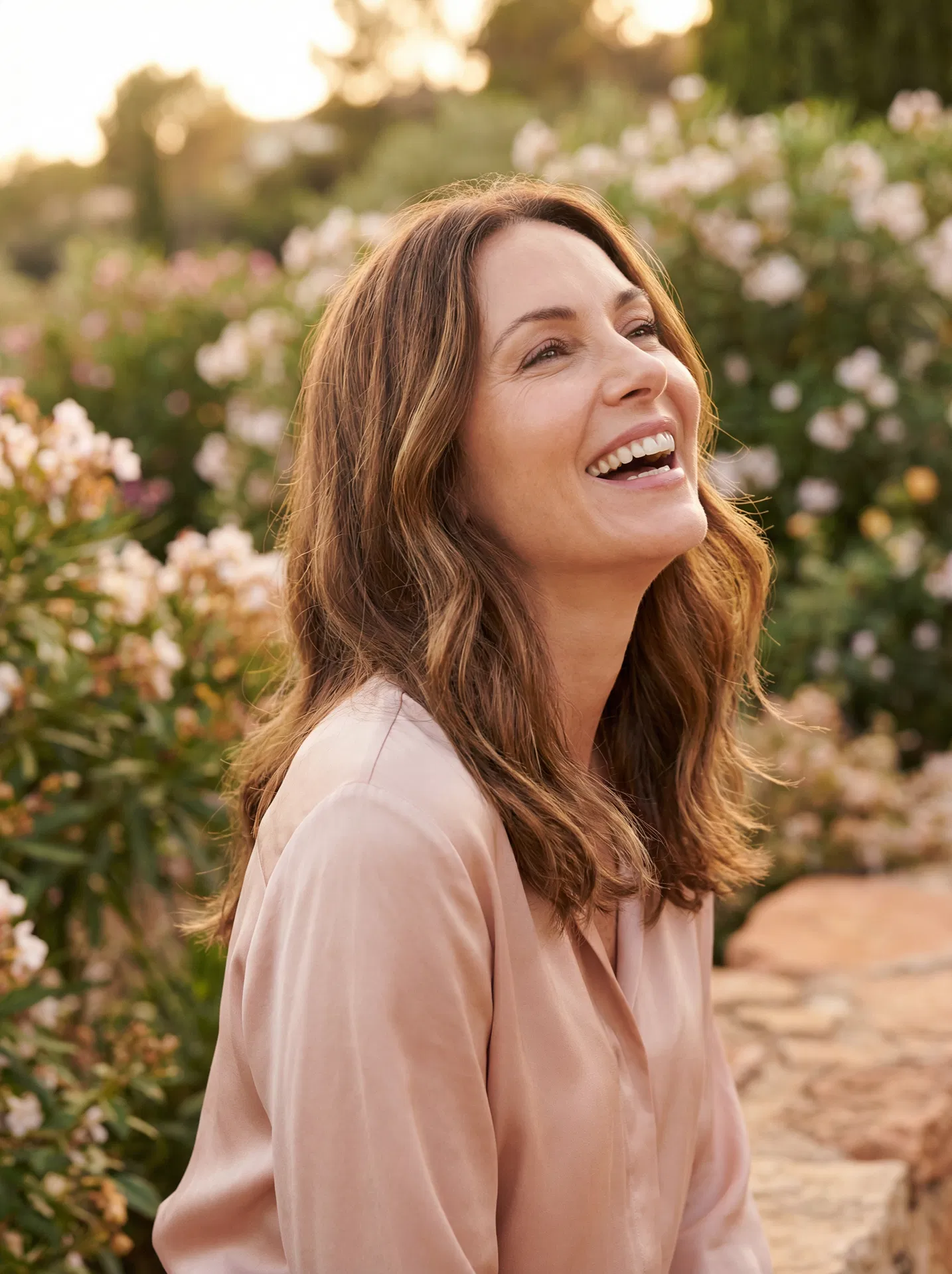 Radiant woman in her 40s laughing in a garden
