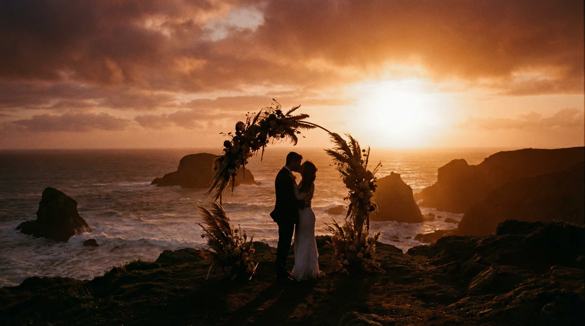 Couple eloping at sunset on a clifftop