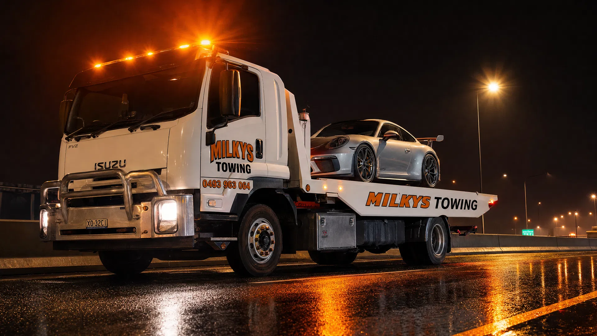 Milkys Towing loading Porsche GT3 at night on highway