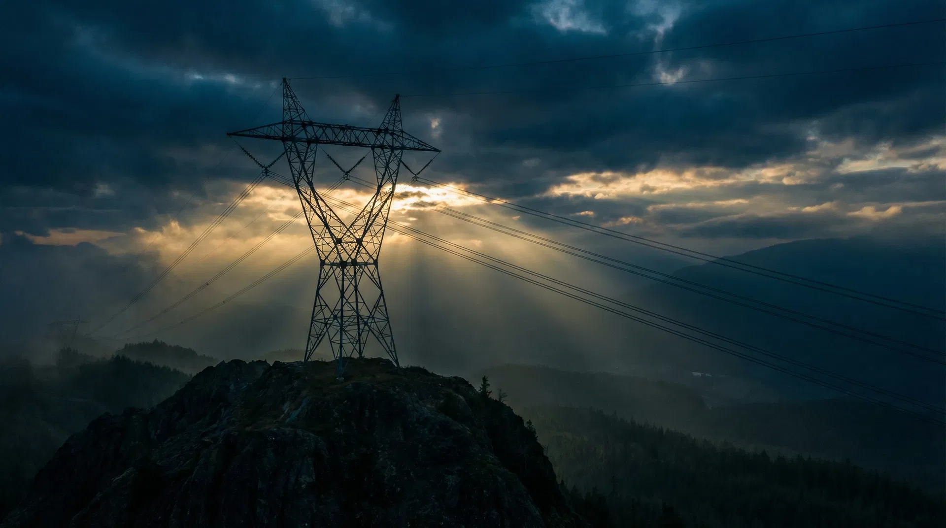 QuatroNext Electric - High-voltage transmission tower against dramatic sky