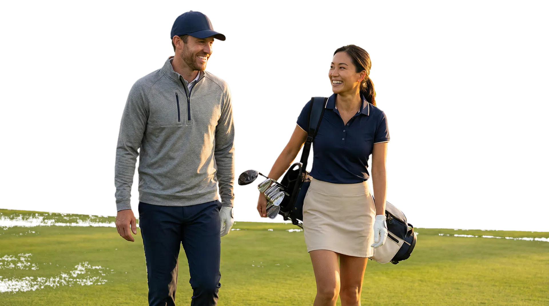 Asian woman and white man in their late 20s to 40s smiling while walking a golf fairway after a shot