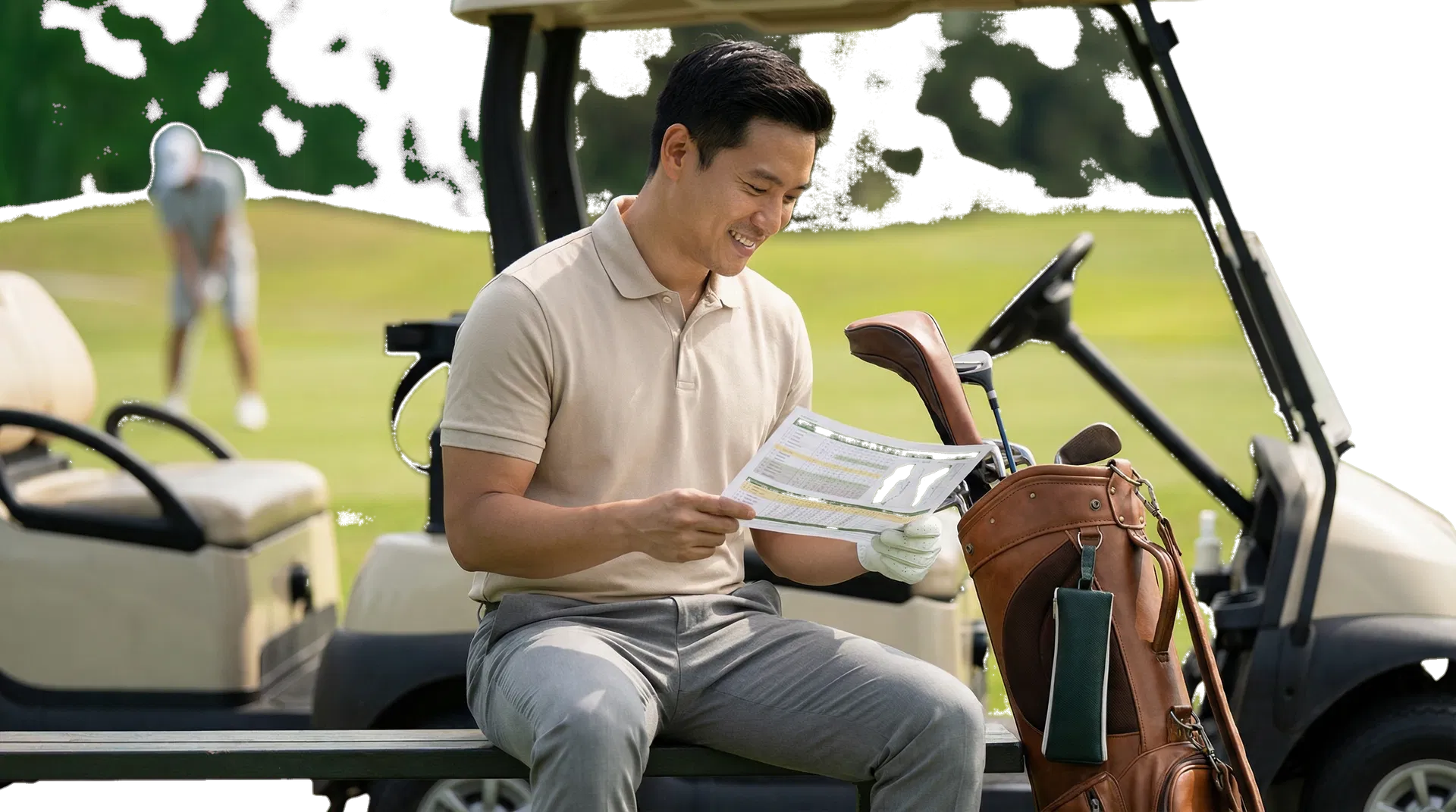 Asian adult man reviewing a golf planning sheet beside a cart with another golfer blurred in the background