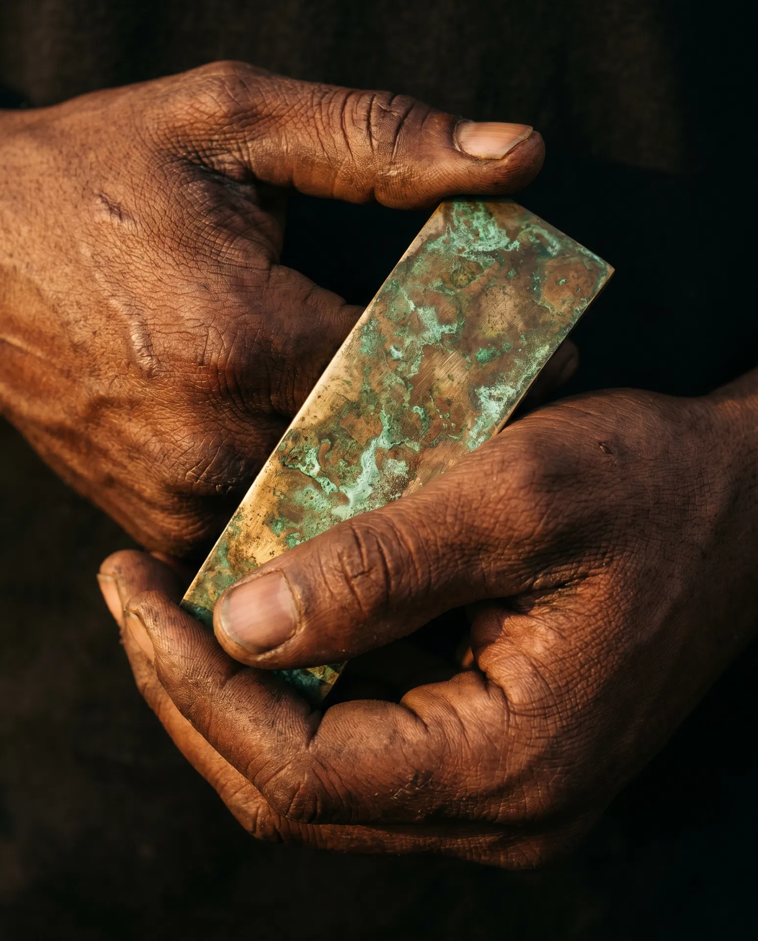 Artisan hands holding patinated brass