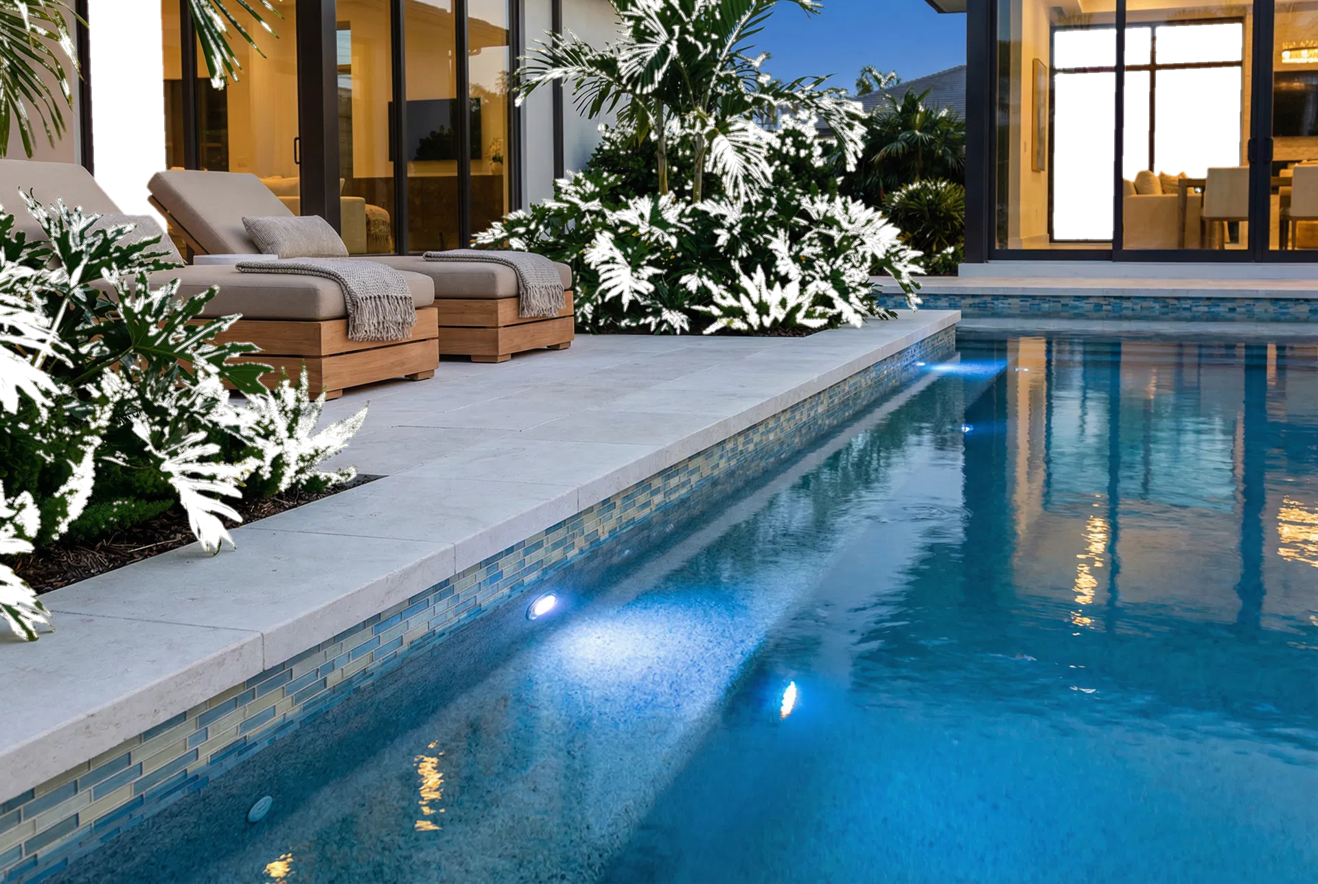 Detailed view of limestone coping, underwater lighting, and luxury seating beside a pool.