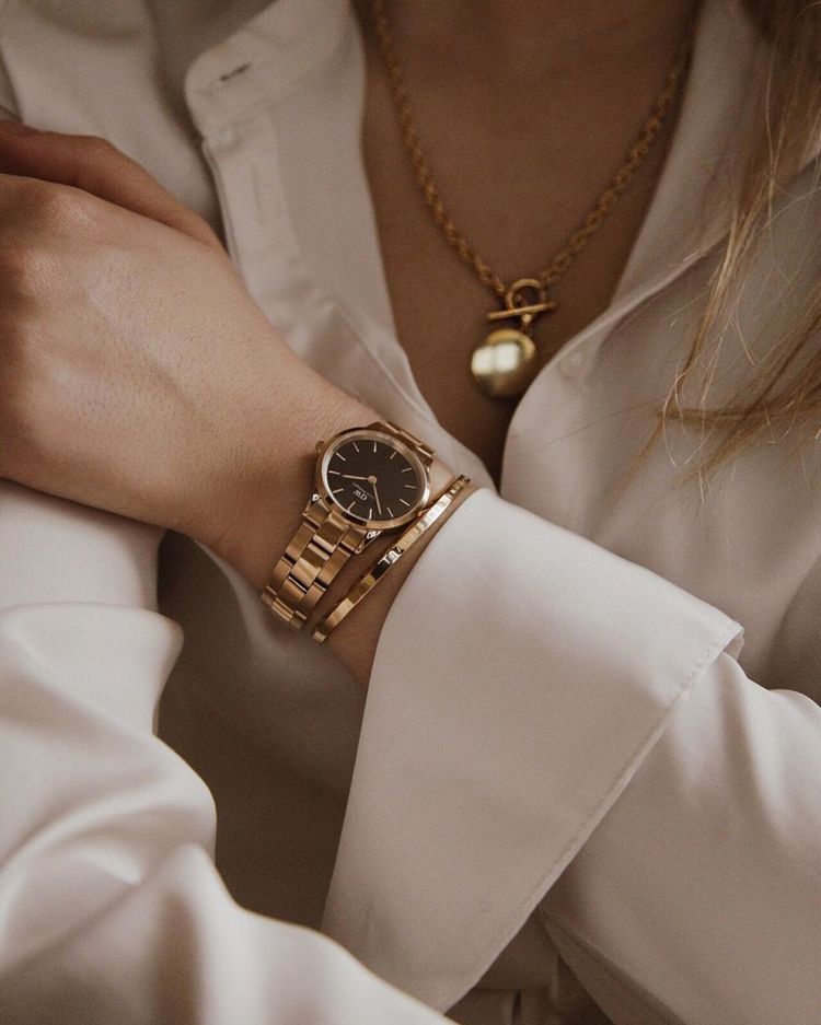 Daniel Wellington gold wrist watch — round black dial, minimalist hour markers, link bracelet, small branding on dial
