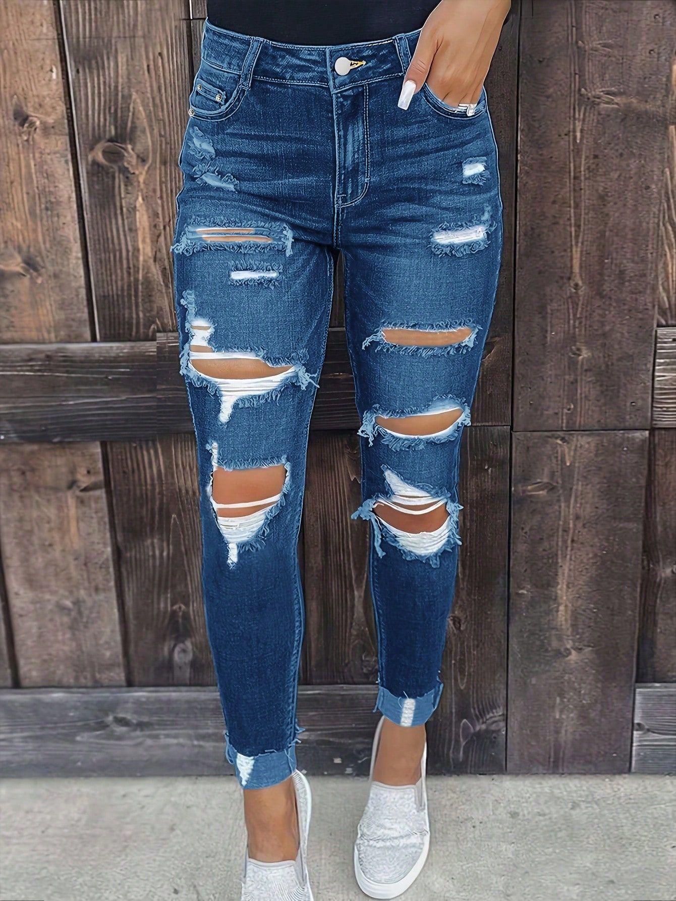 casual dark wash blue jeans — high-waisted, heavily distressed, ripped knees, frayed hem, cuffed ankles
