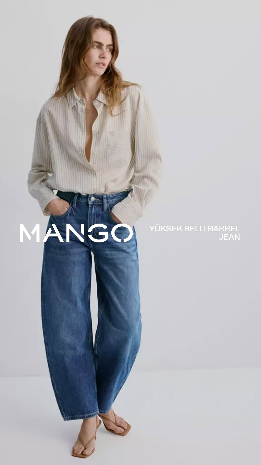 Mango medium wash blue jeans — five-pocket style, visible white stitching, barrel/curved leg silhouette, button and zipper closure