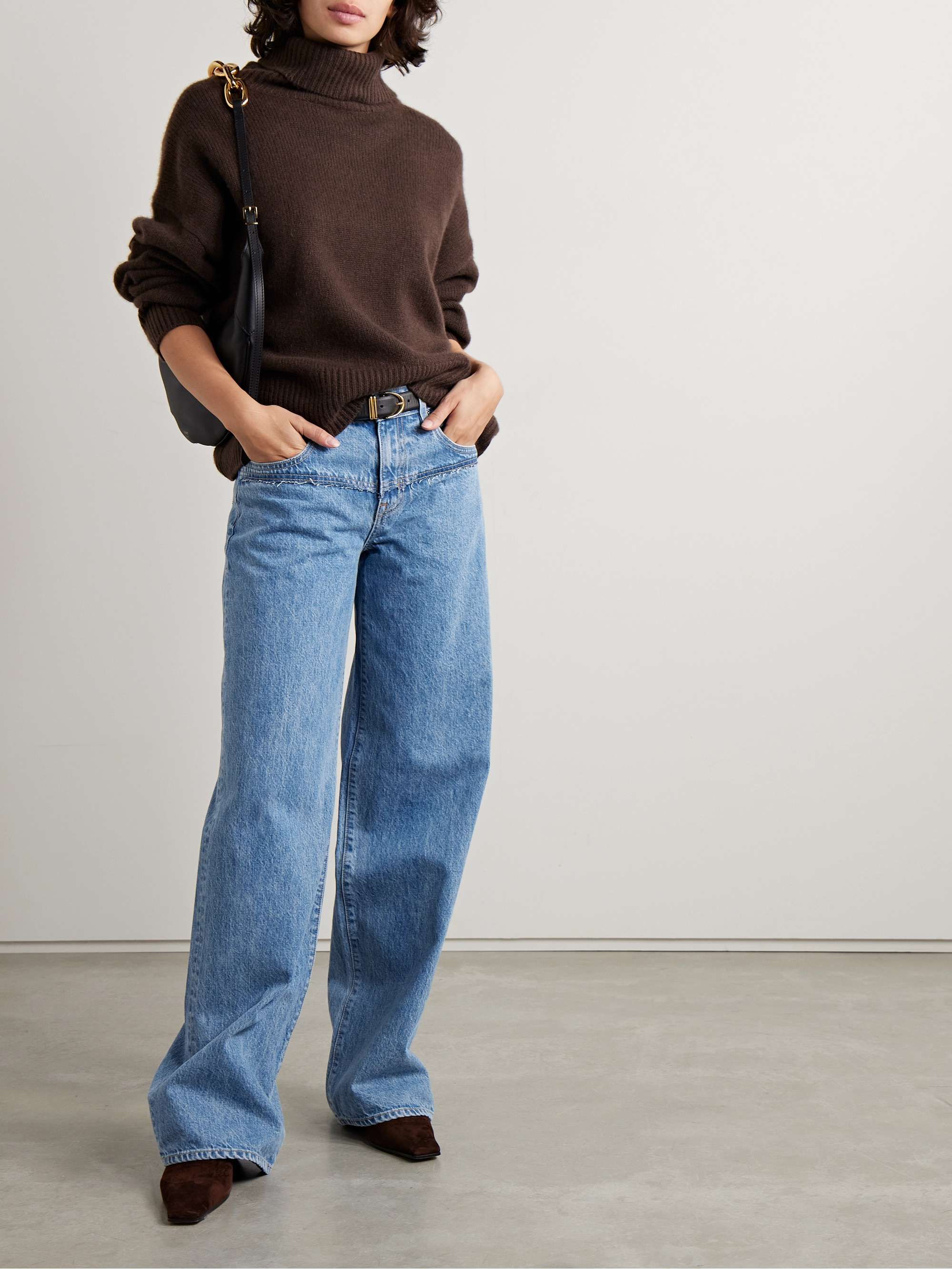 Casual light blue wash jeans — frayed waistline, visible stitching detail at front yoke, wide hem, five-pocket style