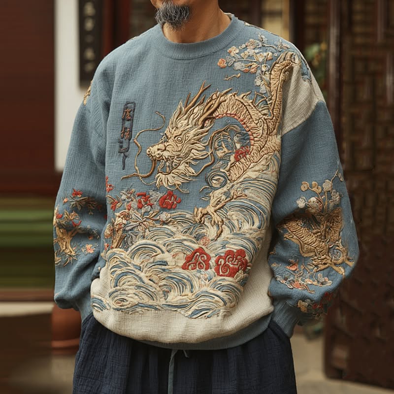 traditional dusty blue crewneck sweatshirt — intricate gold dragon embroidery, wave and cloud motifs, floral embroidery on sleeves, ribbed cuffs and hem, kanji text detail