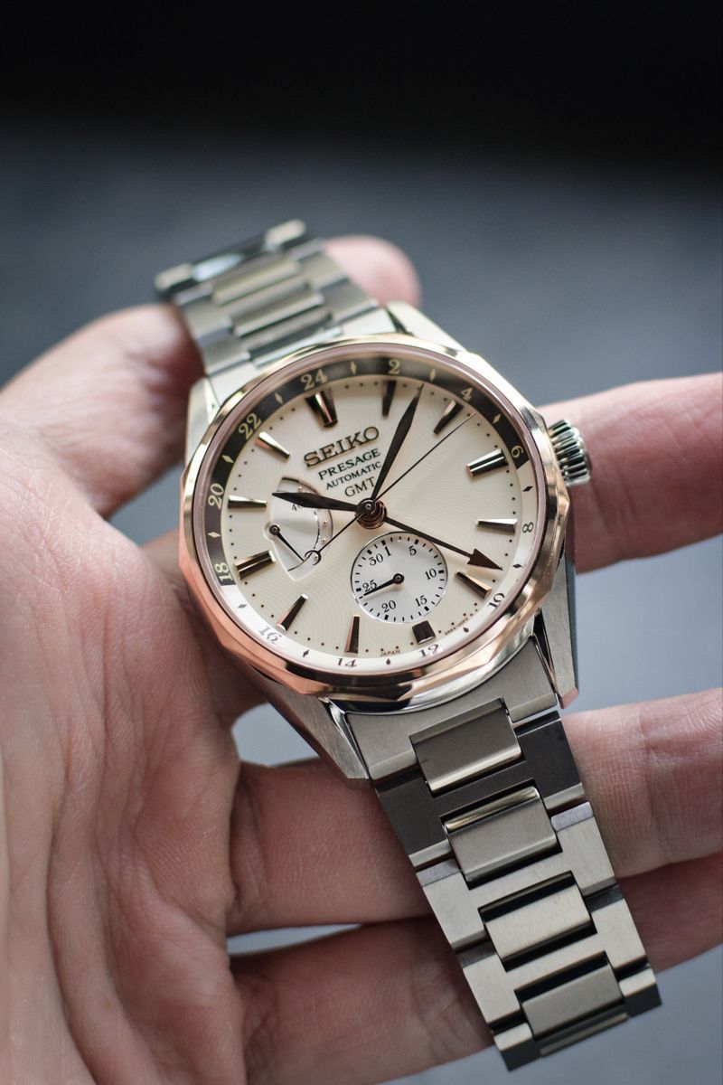 Seiko silver and rose gold watch — round case, multi-link bracelet, cream dial, GMT function, power reserve indicator, sub-dial, rose gold bezel and accents