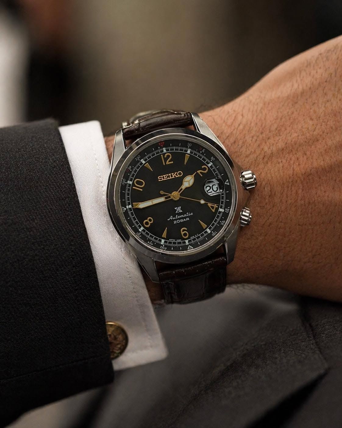 Seiko dark brown strap, silver case, black dial, gold accents wristwatch — automatic movement, internal rotating bezel, date window, gold-tone Arabic numerals and hands, two crowns, crocodile embossed strap