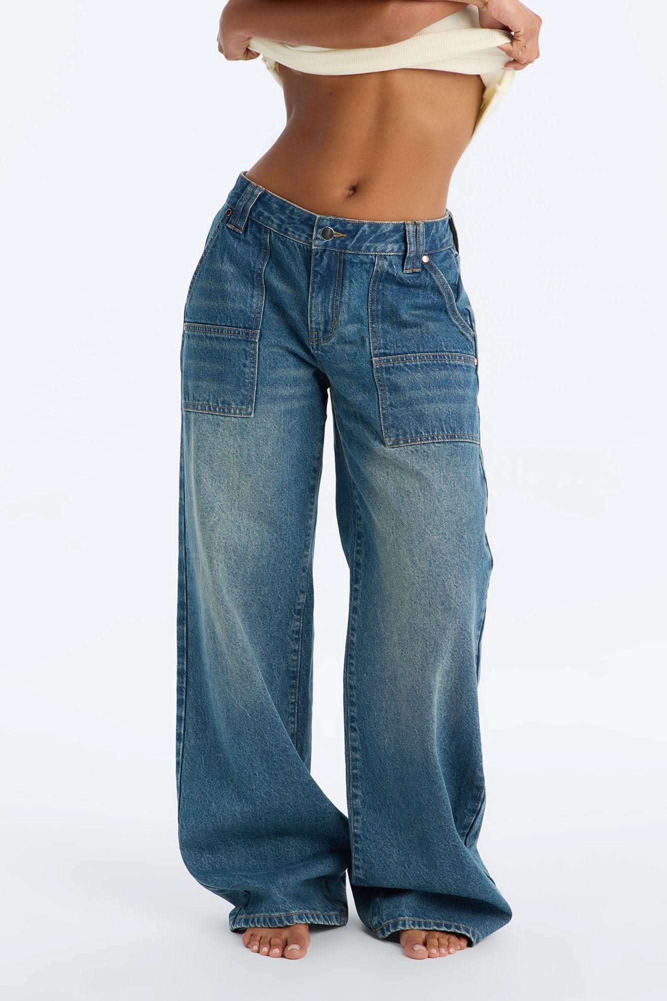 casual medium wash blue denim jeans — large front patch pockets, utility details, faded wash