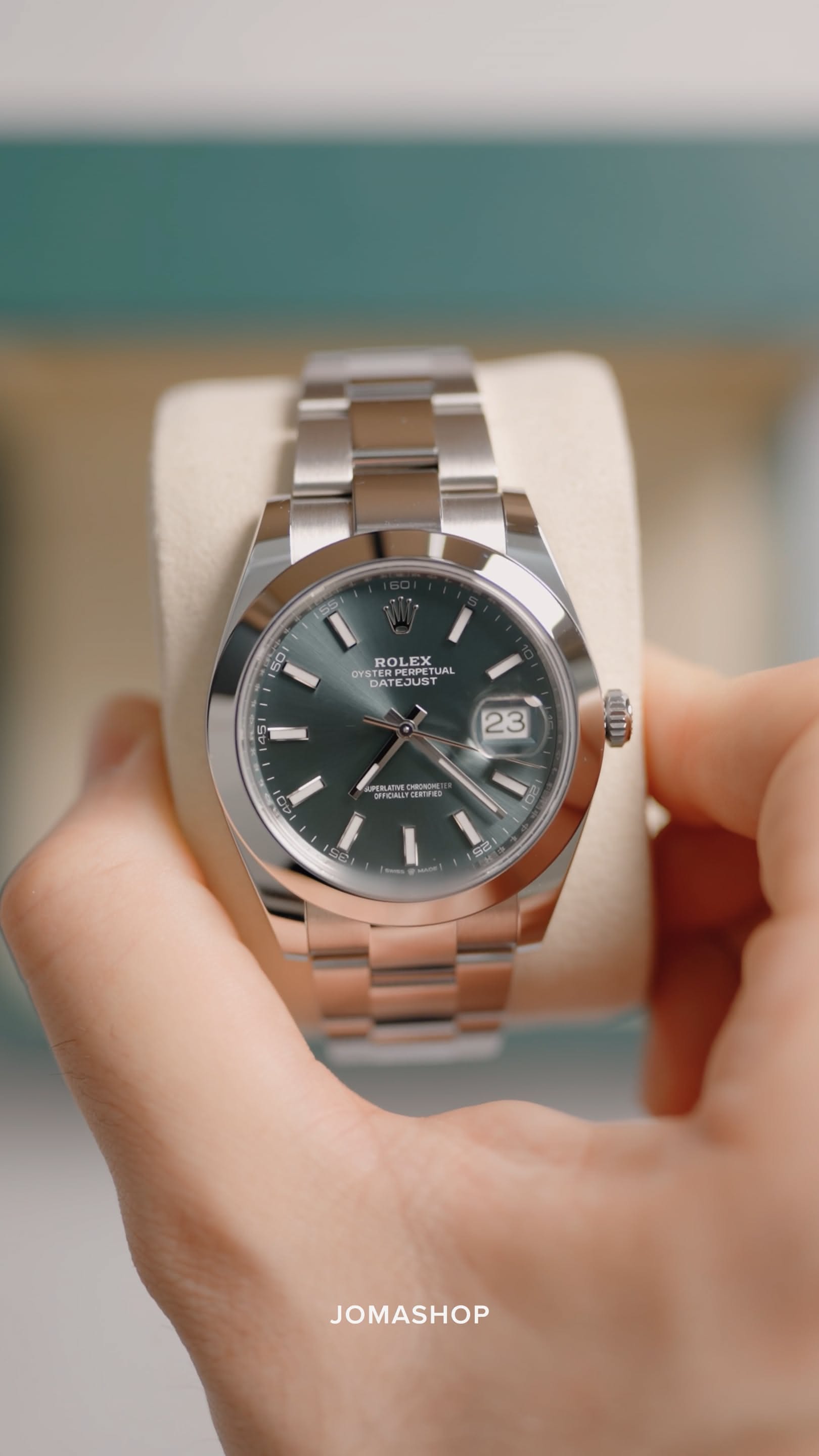 Rolex dark green dial, silver-toned metal wristwatch — round case, smooth bezel, stick hour markers, date display with cyclops lens, oyster bracelet, fluted crown