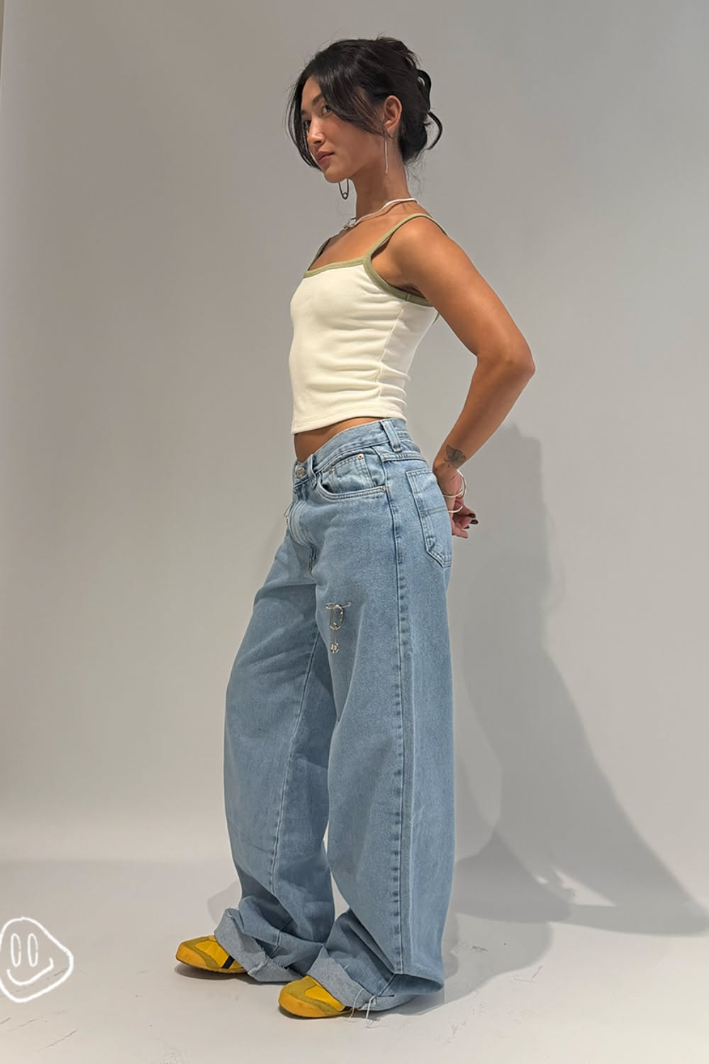 casual light wash blue jeans — distressed cuffs, safety pin embellishment, five-pocket style