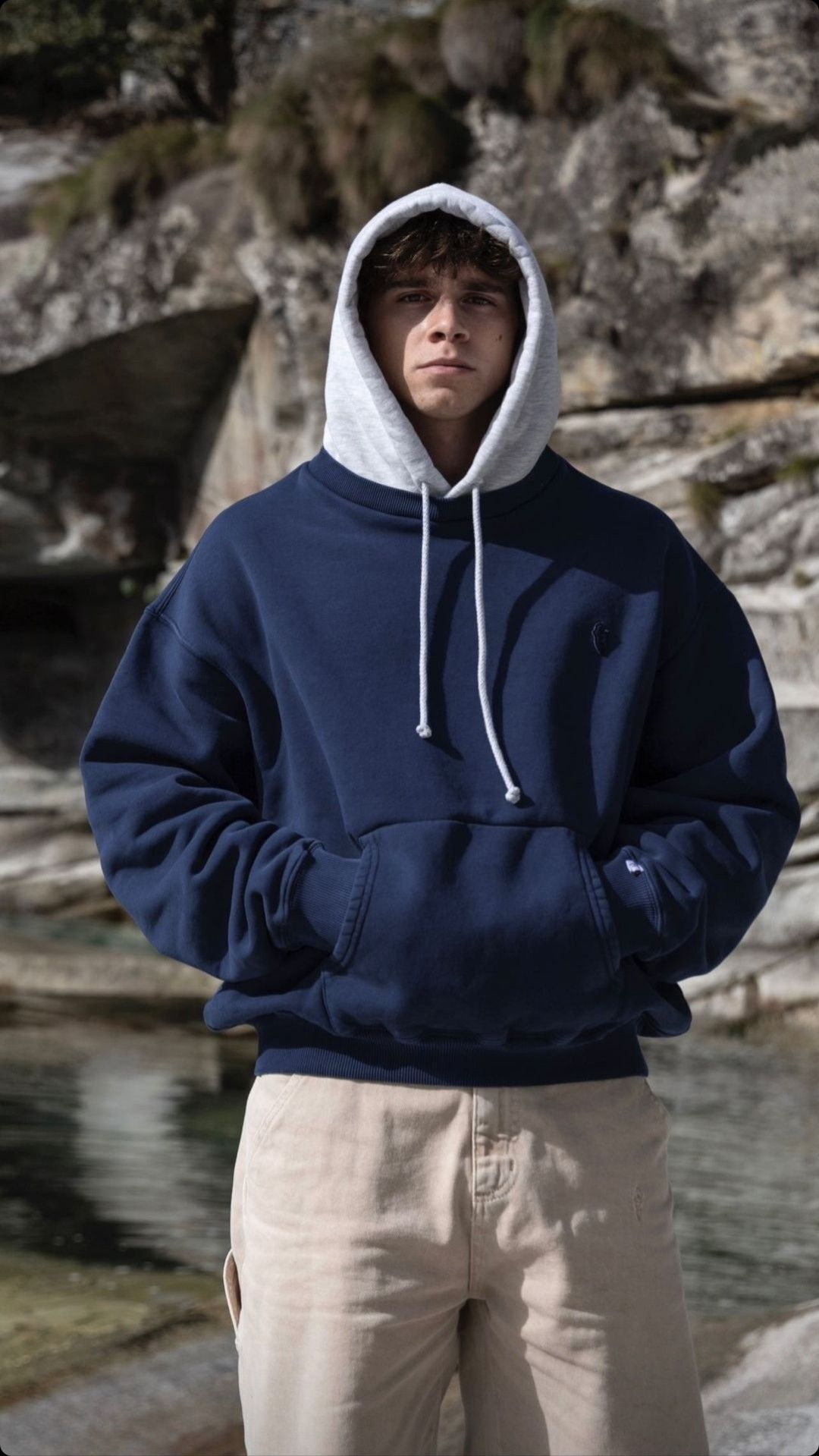 Champion navy blue with grey hood lining hoodie — drawstring hood, kangaroo pocket, ribbed cuffs and hem, small embroidered logo on chest and sleeve