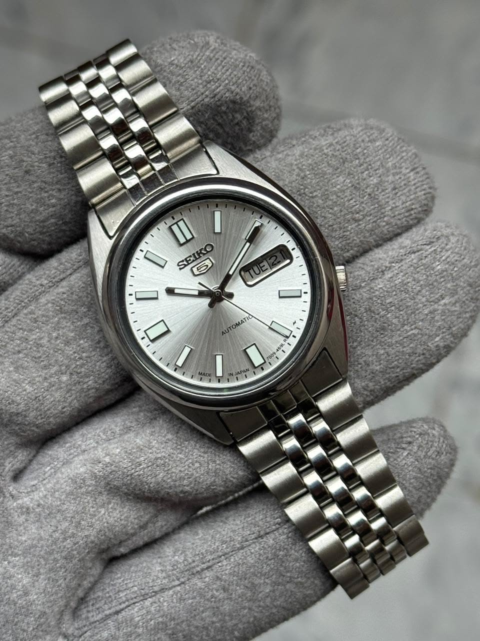 Seiko silver wristwatch — automatic movement, day-date complication, sunburst dial, baton hour markers, jubilee bracelet