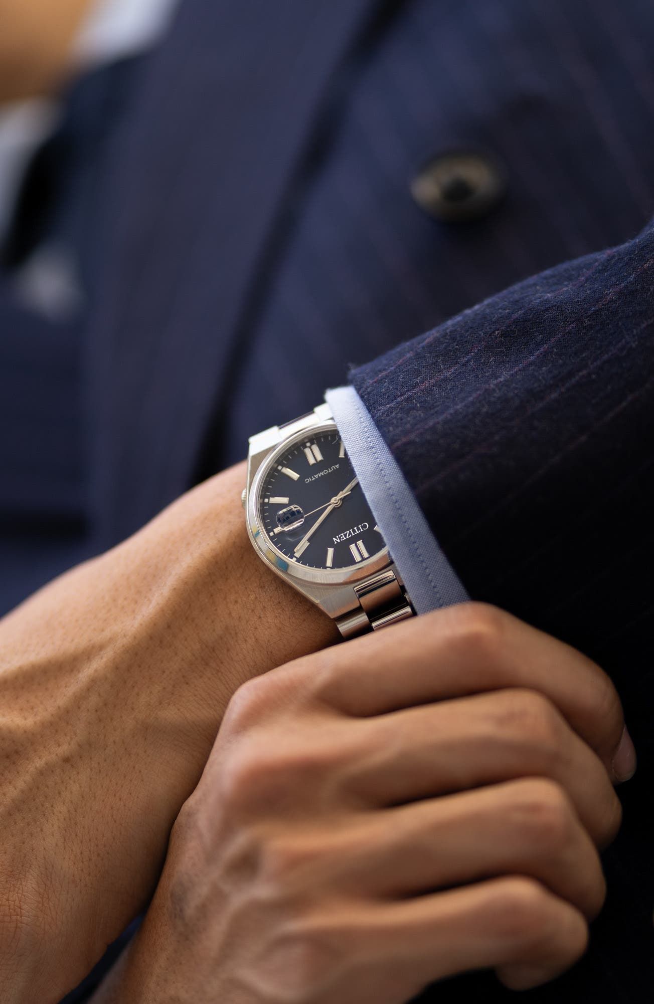 Citizen silver-tone with dark blue dial wristwatch — integrated bracelet, round case, dark blue dial with applied indices, date window at 3 o'clock, luminous hands, 'AUTOMATIC' text on dial