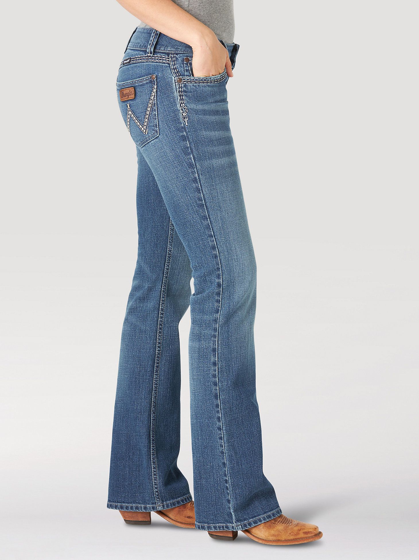 Wrangler medium wash blue bootcut jeans — contrast white stitching, embroidered back pockets, leather brand patch, five-pocket style
