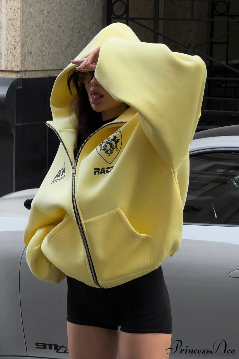 streetwear pastel yellow zip-up hoodie — full zip closure, drop shoulders, large front pockets, black graphic print on chest, ribbed cuffs and hem, hood
