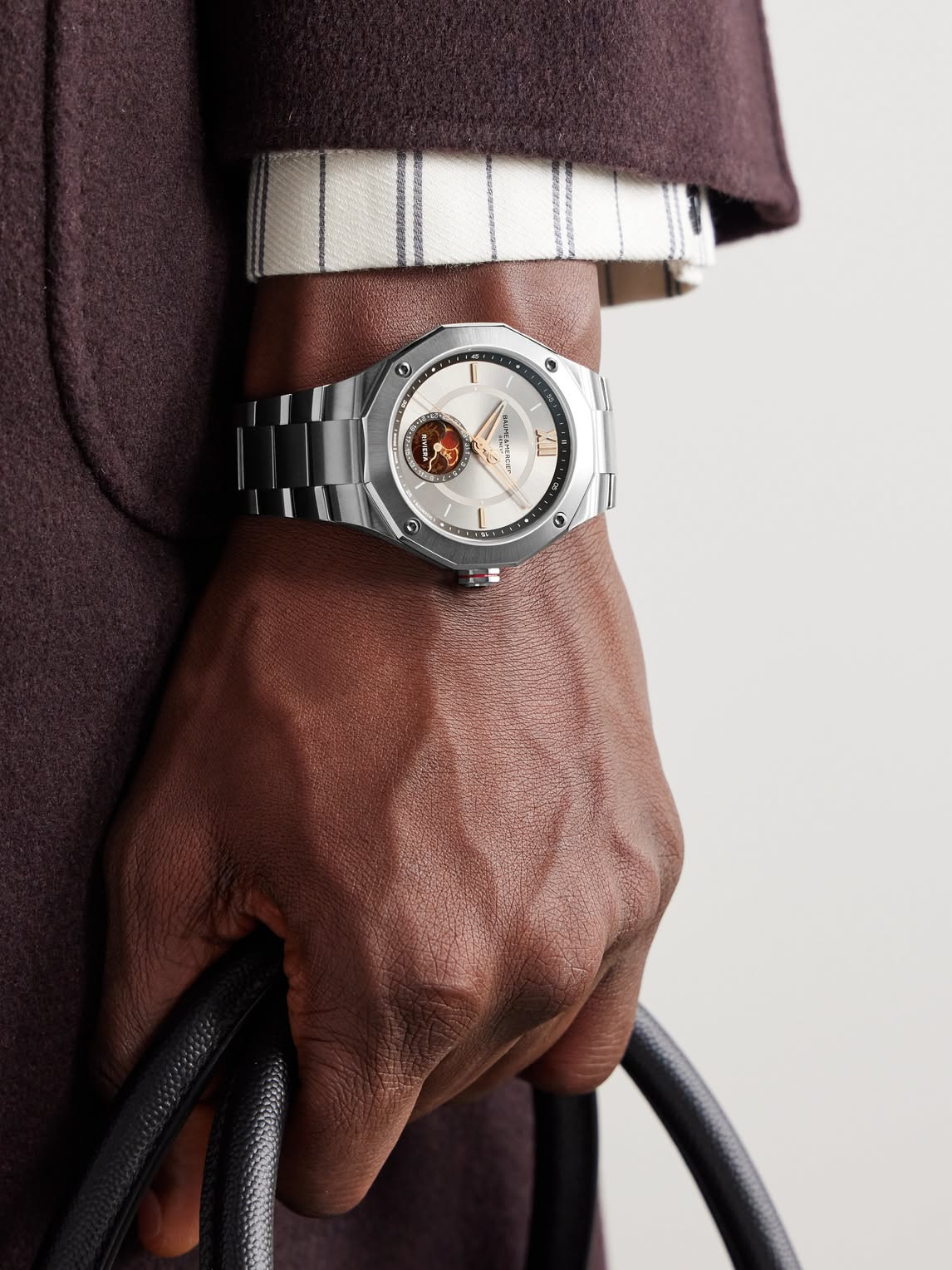 Baume & Mercier silver wrist watch — dodecagonal bezel, exposed balance wheel, moon phase complication, Roman numerals, silver dial, metal bracelet