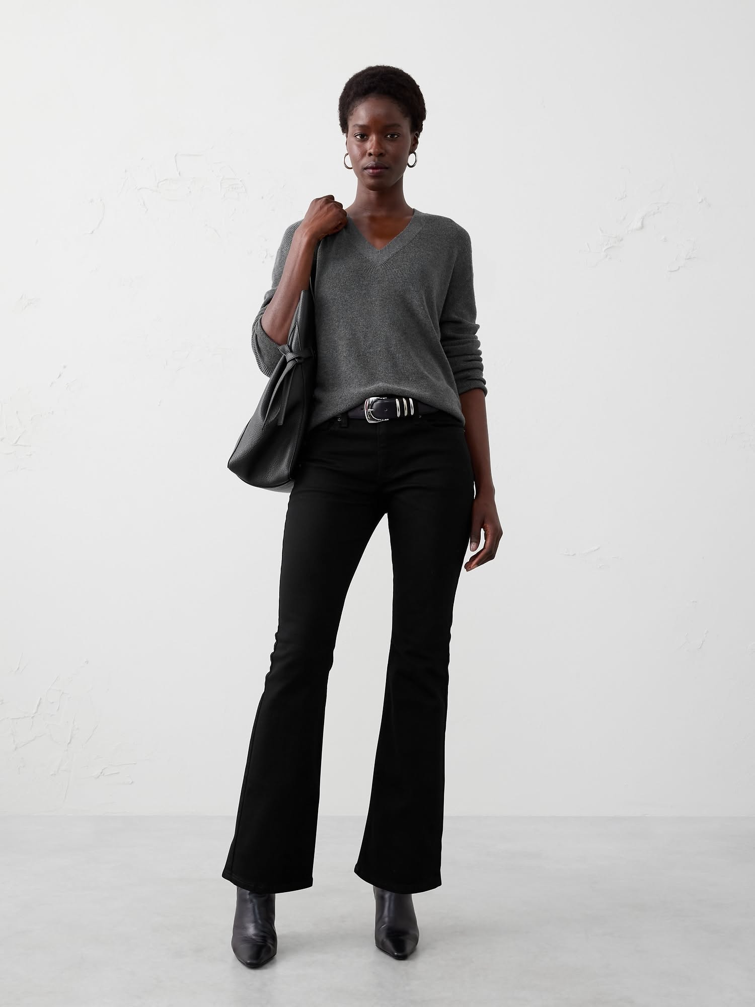 Casual black jeans — mid-rise waist, subtle kick flare at the ankle, classic five-pocket style (implied)
